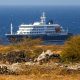 El crucero holandés MV Hondius (atrás), anclado frente a la costa de la ciudad de Praia en la isla de Santiago, Cabo Verde, este lunes 4 de mayo de 2026, después de que tres personas murieran a bordo a causa de un síndrome respiratorio agudo. La Organización Mundial de la Salud (OMS) informó de un caso confirmado y cinco casos sospechosos adicionales de infección por hantavirus en el buque que navega en el Océano Atlántico. Tres de los afectados han muerto y uno se encuentra actualmente en cuidados intensivos en Sudáfrica. (Cabo Verde, Sudáfrica) EFE/EPA/ELTON MONTEIRO