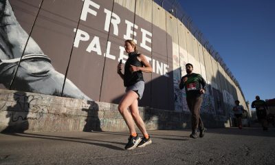 Belén (-), 08/05/2026.- Atletas palestinos e internacionales corren junto a grafitis en la barrera de separación israelí durante la décima Maratón Internacional de Palestina en la ciudad de Belén, en Cisjordania, el 8 de mayo de 2026. Según los organizadores, miles de corredores participaron en el evento, que incluyó una maratón completa, una media maratón y carreras de 10 y 5 kilómetros. (Maratón) EFE/EPA/ALAA BADARNEH