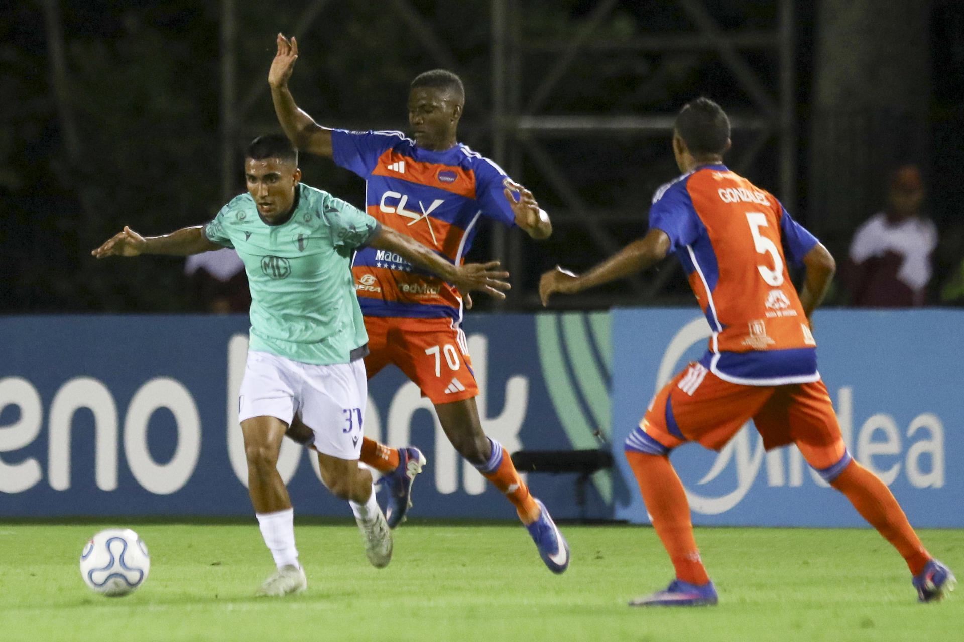 Robinson Flores (c), de Puerto Cabello, disputa el balón con Ramiro Peralta (i), de Juventud, este jueves en un partido de la Copa Sudamericana en el estadio Misael Delgado, en Valencia (Venezuela). EFE/ Juan Carlos Hernández