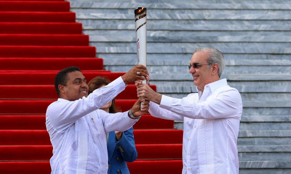 Fotografía cedida este miércoles por la Presidencia de la República Dominicana que muestra al mandatario Luis Abinader (d) y el presidente del Comité Organizador de Santo Domingo 2026, José Monegro, sosteniendo la llama olímpica de los Juegos Centroamericanos y del Caribe durante una ceremonia en el Palacio Nacional en Santo Domingo. EFE/ Presidencia de la República Dominicana /SOLO USO EDITORIAL