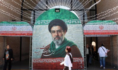 Iraníes caminan junto a una imagen del líder supremo de Irán, el ayatolá Mojtaba Jamenei, en una calle de Teherán, Irán, el pasado 6 de mayo de 2026. El presidente de EE.UU., Donald Trump, anunció la pausa de la operación de escolta de buques a través del Estrecho de Ormuz, insinuando avances en las conversaciones de paz con Teherán. (Teherán) EFE/EPA/ABEDIN TAHERKENAREH