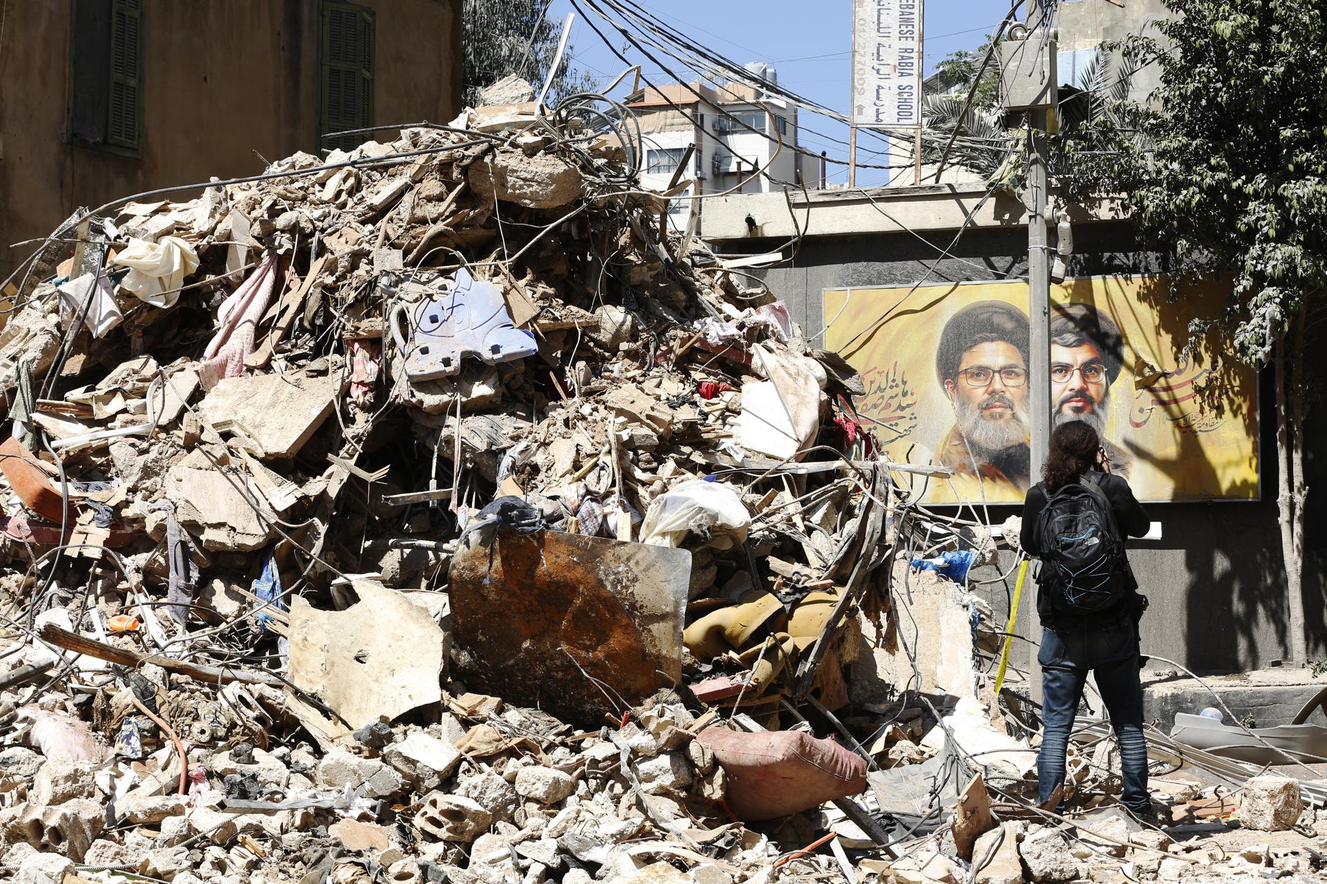 Una mujer pasea por un edificio parcialmente dañado objetivo de un ataque israelí en el barrio de Haret Hreik, suburbio sur de Beirut, Líbano, 07 de mayo de 2026.EFE/EPA/STRINGER