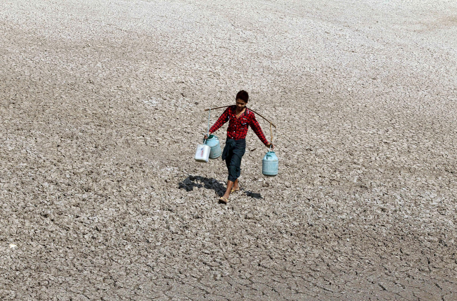En la imagen de archivo, un niño acarrea unos bidones con agua en plena sequía a causa de El Niño en Mandalay, Birmania. EPA/HEIN HTET