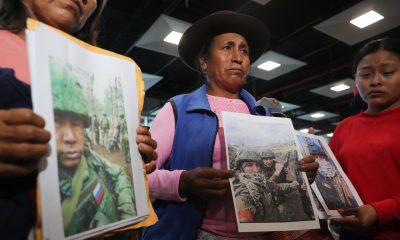 Familiares de peruanos reclutados por Rusia para la guerra contra Ucrania fueron captados este 4 de mayo al sostener fotografías de sus allegados, en el aeropuerto internacional Jorge Chávez, cerca a Lima (Perú). EFE/Paolo Aguilar