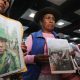 Familiares de peruanos reclutados por Rusia para la guerra contra Ucrania fueron captados este 4 de mayo al sostener fotografías de sus allegados, en el aeropuerto internacional Jorge Chávez, cerca a Lima (Perú). EFE/Paolo Aguilar