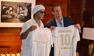 El astro brasileño Ronaldinho Gaúcho (i) y el presidente del Ravenna, Ignazio Cipriani, posan con camisetas durante el anunció de su regreso al fútbol profesional a los 46 años de la mano del Ravenna FC italiano este martes, en Miami (Estados Unidos). EFE/ Antoni Belchi