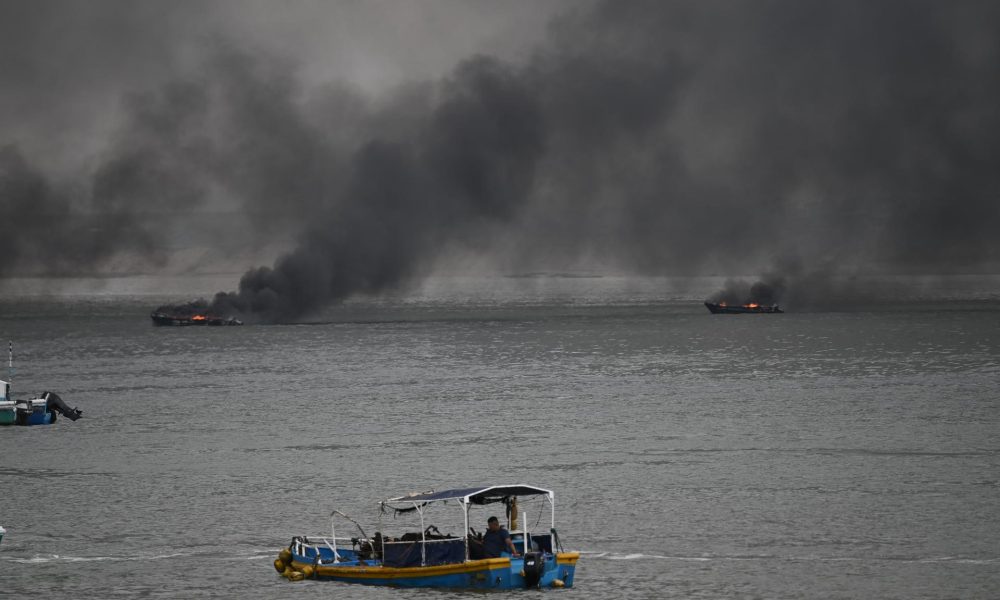 Fotografía de dos embarcación incendiándose este 6 de junio de 2026, en el puerto de Manta (Ecuador). EFE/ Ariel Ochoa