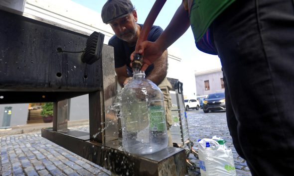 Personas se abastecen de agua tras la interrupción del servicio en San Juan (Puerto Rico). EFE/ Thais Llorca