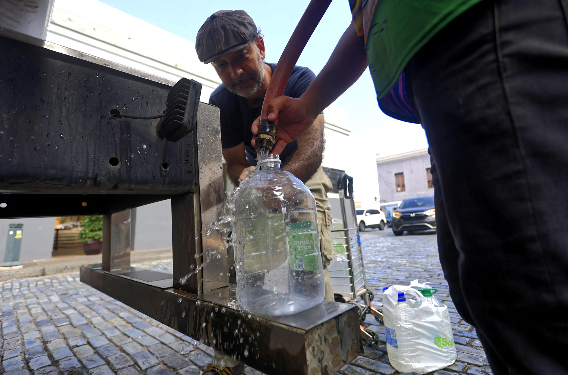 Personas se abastecen de agua tras la interrupción del servicio en San Juan (Puerto Rico). EFE/ Thais Llorca