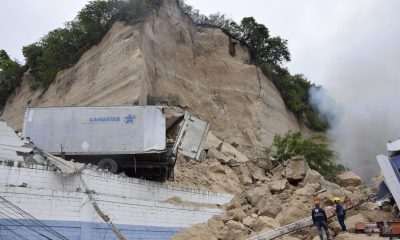 Integrantes del Cuerpo de Bomberos de Honduras atienden el derrumbe de un cerro sobre una bodega en Tegucigalpa (Honduras). EFE/ STR