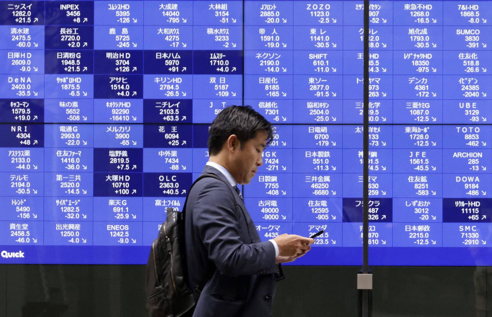 TOKIO (Japón), 23/06/2026.- Un transeúnte pasa junto a una pantalla de indicadores bursátiles en Tokio, Japón, el 23 de junio de 2026. 
EFE/EPA/FRANCK ROBICHON