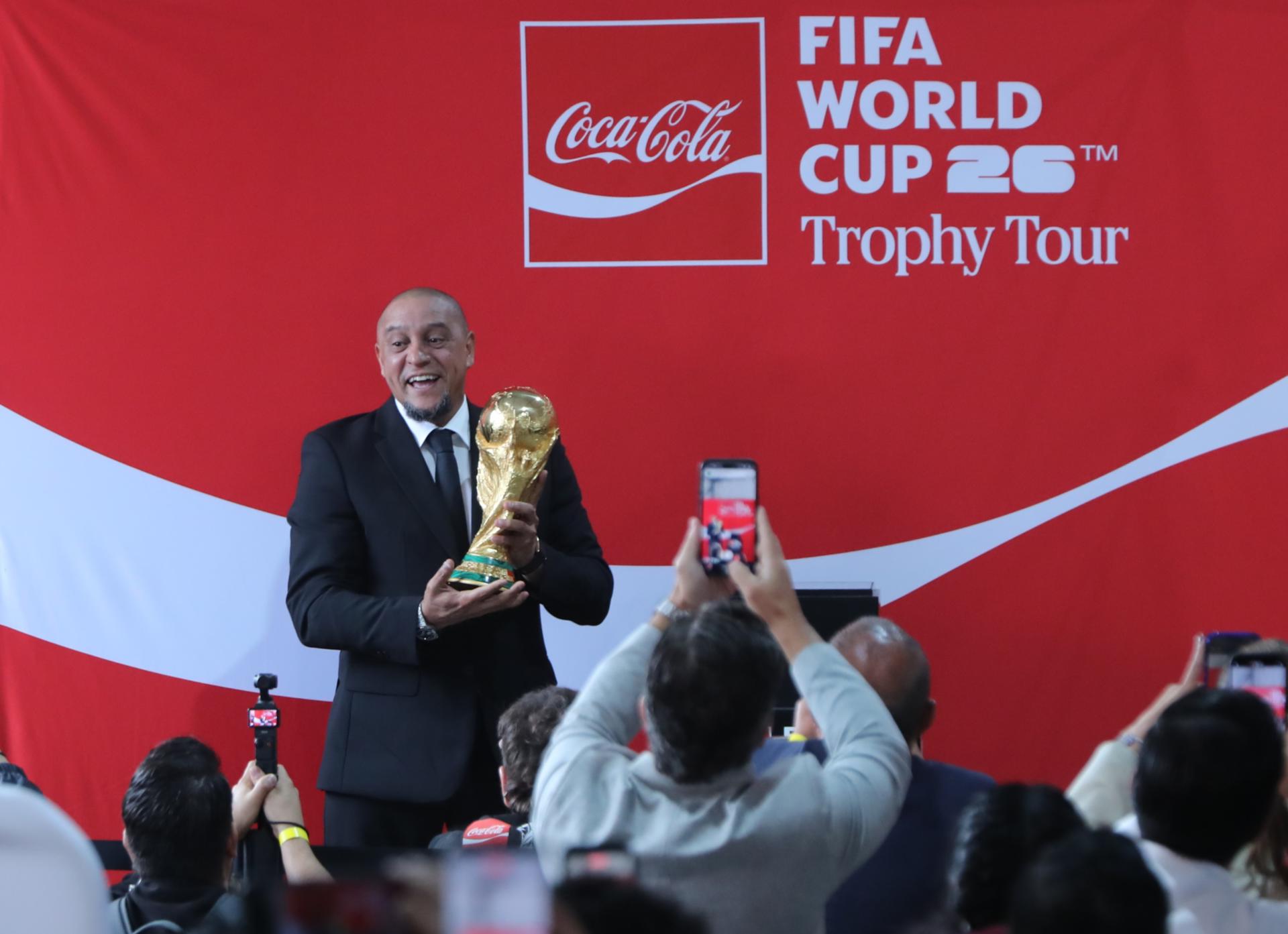 El exjugador brasileño Roberto Carlos carga la Copa Mundial 2026 este viernes, durante un evento en la Ciudad de México (México). EFE/ Mario Guzmán