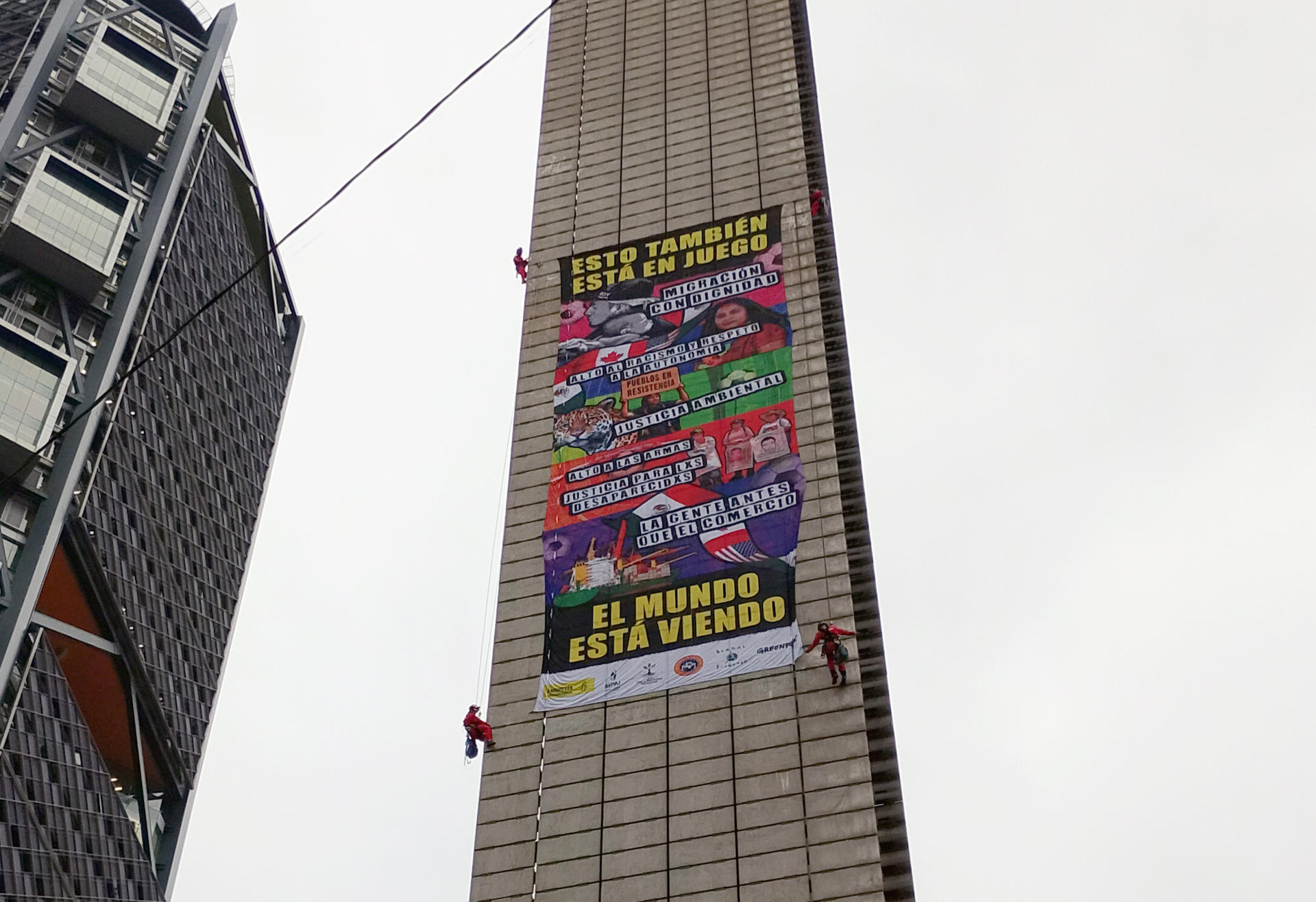 Activistas de Greenpeace México colocan un afiche en la Estela de Luz este martes, en Ciudad de México (México). EFE/Eduardo Guerra