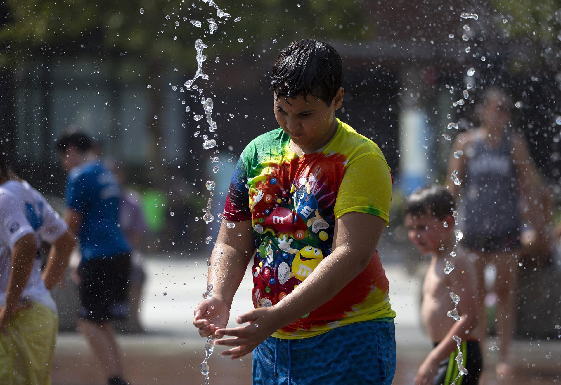 Un niño se refresca en una fuente en Boston (EE.UU.). Fotografía de archivo. EFE/CJ GUNTHER