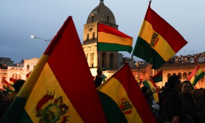 Personas ondean banderas durante un cabildo donde exigen al gobierno declarar estado de excepción este martes, en el atrio de la basílica de San Francisco en La Paz (Bolivia). EFE/ Luis Gandarillas