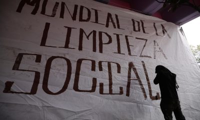 Un activista posa junto a un cartel durante una manifestación, donde acusan a las autoridades de intentar "borrar" sus demandas por el acceso al agua y la defensa del territorio, tras el retiro de un mural comunitario instalado en las inmediaciones del estadio Azteca, este martes en Ciudad de México (México). EFE/ José Méndez