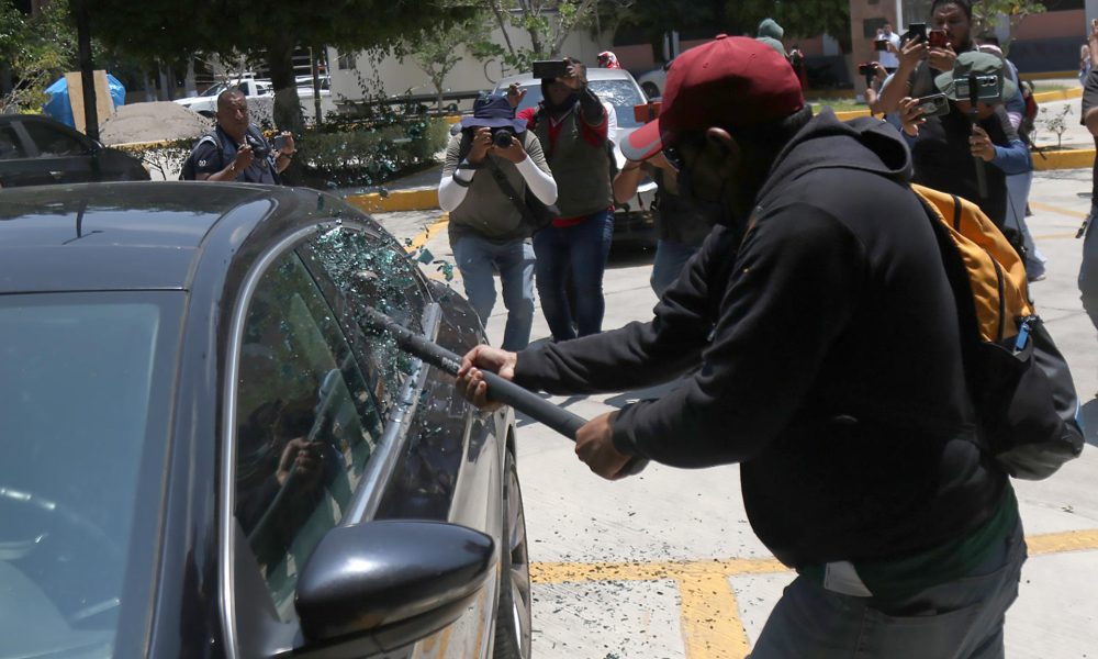Una persona vandaliza un vehículo este martes, durante una protesta de integrantes de la Coordinadora Nacional de Trabajadores de la Educación (CNTE), en Chilpancingo (México). EFE/ José Luis De La Cruz