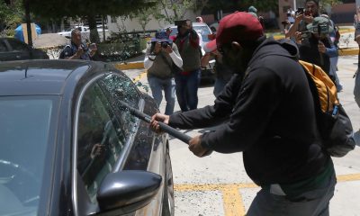 Una persona vandaliza un vehículo este martes, durante una protesta de integrantes de la Coordinadora Nacional de Trabajadores de la Educación (CNTE), en Chilpancingo (México). EFE/ José Luis De La Cruz