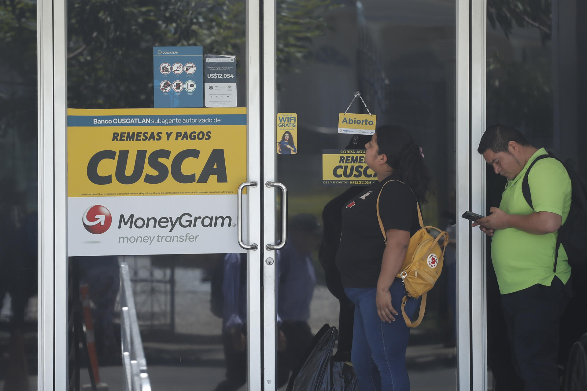 Un grupo de personas fue captado este 15 de junio al hacer fila para ingresar a una agencia de giros de remesas, en San Salvador (El Salvador). EFE/Rodrigo Sura
