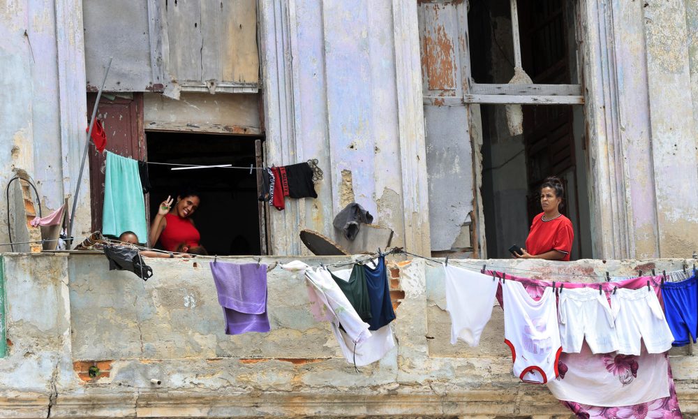 Un par de mujeres y un niño fueron captados este 12 de junio en las ventanas de un inquilinato en el centro de La Habana, luego de que el presidente de Cuba, Miguel Díaz-Canel, anunciara un paquete de reformas en el turismo, el comercio exterior, la inversión extranjera y el papel del sector privado en su país. EFE/Ernesto Mastrascusa