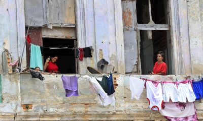 Un par de mujeres y un niño fueron captados este 12 de junio en las ventanas de un inquilinato en el centro de La Habana, luego de que el presidente de Cuba, Miguel Díaz-Canel, anunciara un paquete de reformas en el turismo, el comercio exterior, la inversión extranjera y el papel del sector privado en su país. EFE/Ernesto Mastrascusa