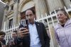 El candidato a la vicepresidencia por el movimiento de ultraderecha Defensores de la Patria, José Manuel Restrepo (c), sostiene un celular frente a la iglesia del Voto Nacional este viernes, en Bogotá (Colombia). EFE/ Mauricio Dueñas Castañeda
