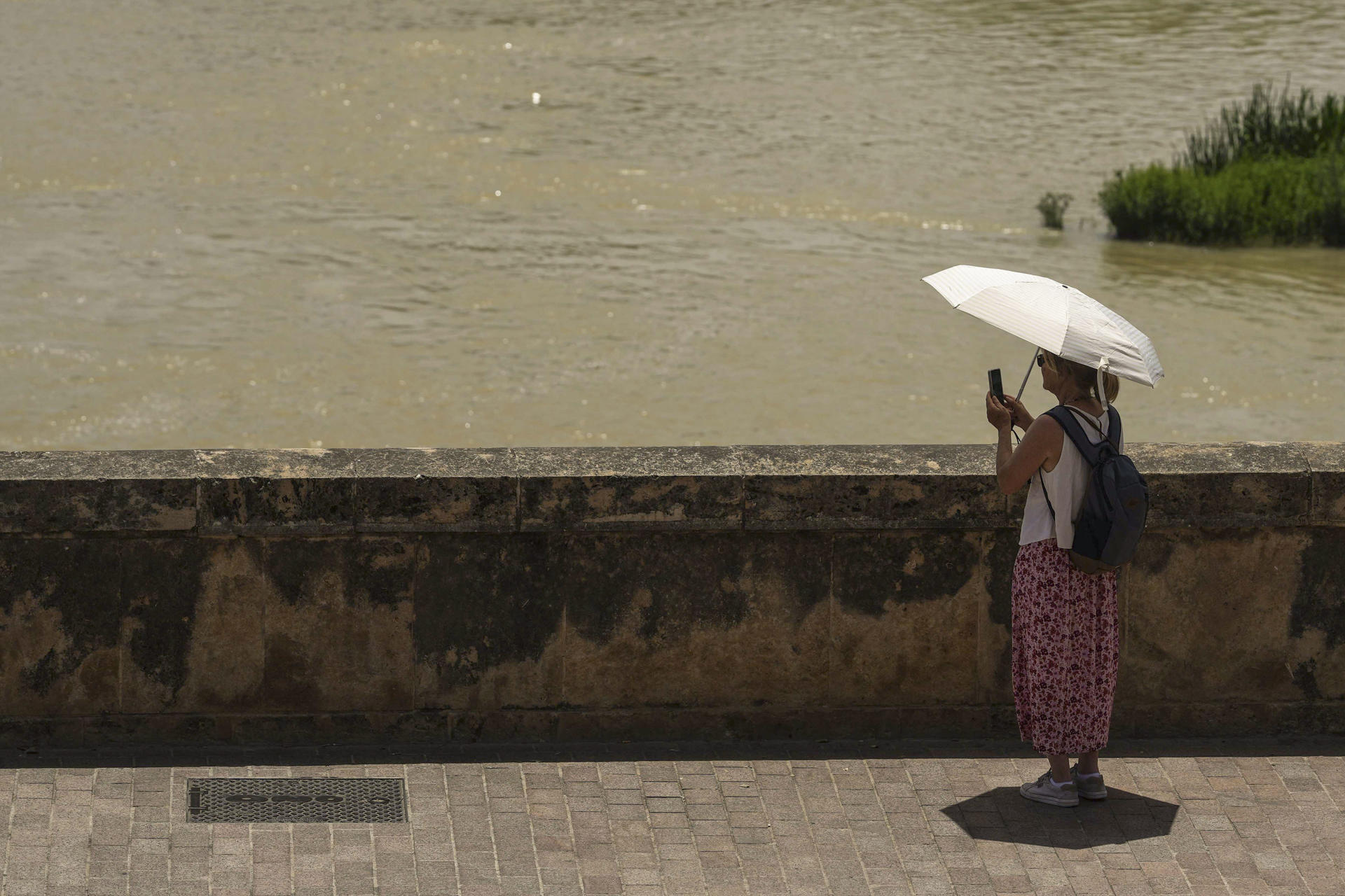 Una turista toma una foto del río Guadalquivir en Córdoba, España, este lunes. EFE/ Rafa Alcaide
