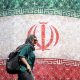 TEHERÁN (IRÁN), 14/06/2026.- Una mujer iraní pasa junto a una valla publicitaria con la bandera nacional de Irán en la plaza Enqelab de Teherán, Irán, este domingo.
 EFE/EPA/ABEDIN TAHERKENAREH