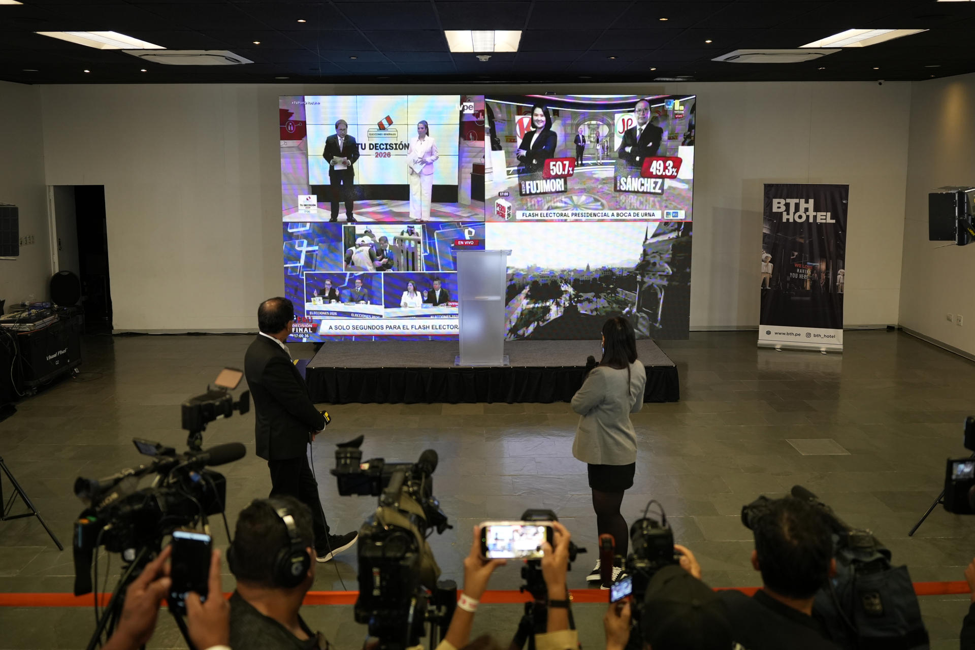 Personas fueron captada este 7 de junio al observar en un televisor los resultados de los sondeos a pie de urna, tras el cierre de los colegios electorales de la segunda vuelta de las elecciones presidenciales de Perú, donde dan un empate técnico entre la derechista Keiko Fujimori y el izquierdista Roberto Sánchez, en Lima (Perú). EFE/John Reyes
