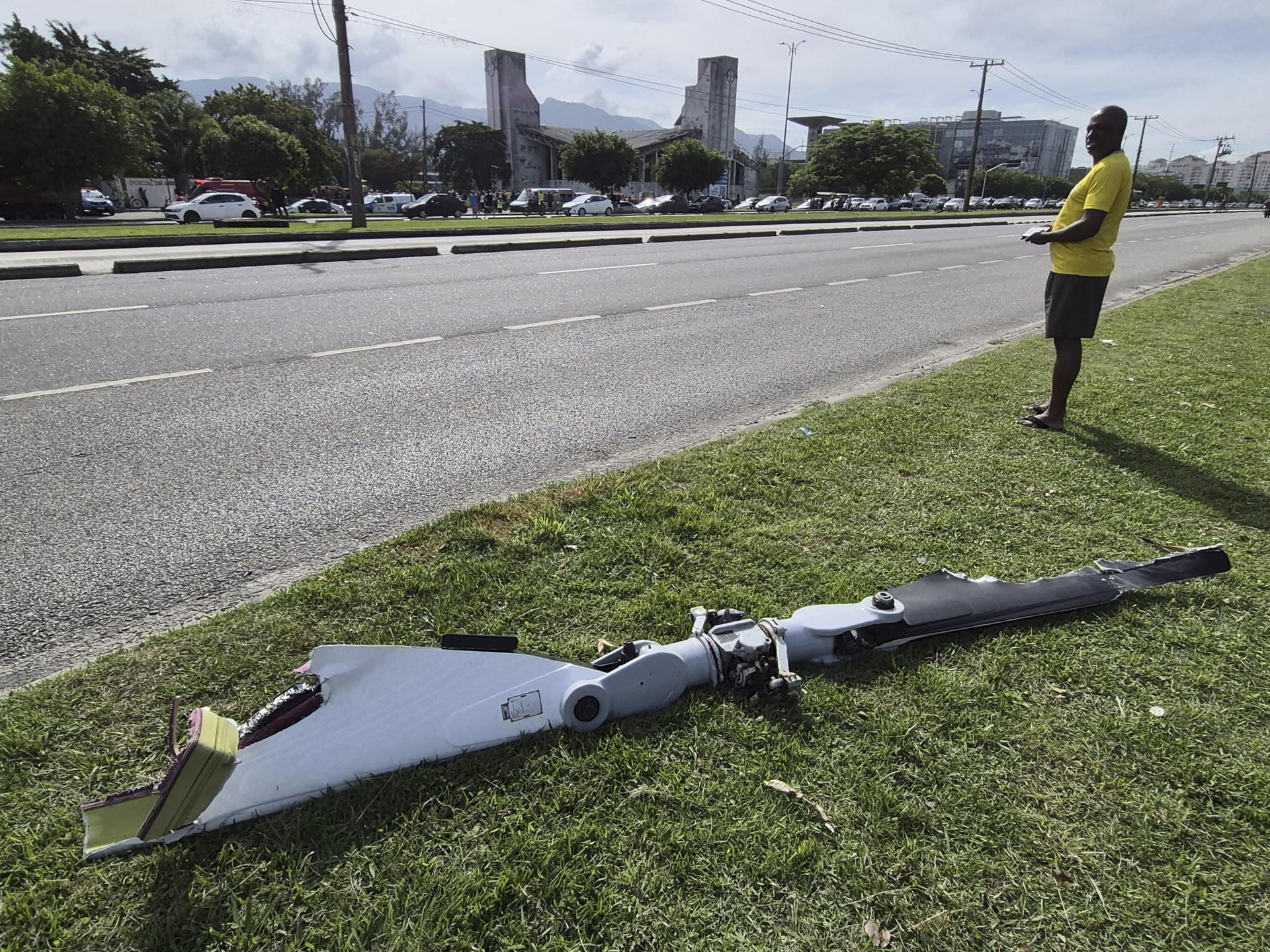 Fotografía cedida este 14 de junio por Roberta Durço que captó a una persona al observar un fragmento de uno de los dos helicópteros que colisionaron este domingo en el aire, en el barrio Recreio dos Bandeirantes, en Río de Janeiro (Brasil). EFE/Roberta Durço