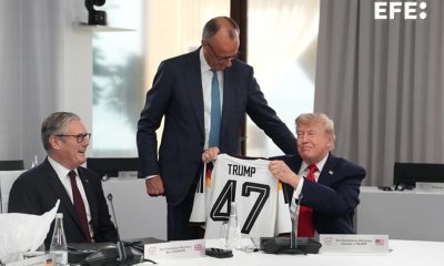 El presidente de Estados Unidos, Donald Trump (d), sostiene una camiseta de Alemania con su apellido y el número 47, junto al primer ministro británico, Keir Starmer (i), y el canciller alemán, Friedrich Merz (de pie), durante la cumbre del G7. EFE/ THIBAULT CAMUS / POOL *Prohibido su uso por MAXPPP*