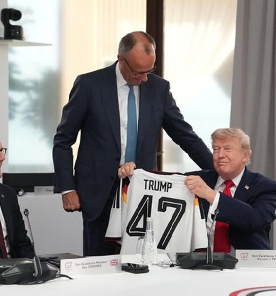 El presidente de Estados Unidos, Donald Trump (d), sostiene una camiseta de Alemania con su apellido y el número 47, junto al primer ministro británico, Keir Starmer (i), y el canciller alemán, Friedrich Merz (de pie), durante la cumbre del G7. EFE/ THIBAULT CAMUS / POOL *Prohibido su uso por MAXPPP*