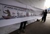 Activistas sostienen un cartel durante una manifestación, donde acusan a las autoridades de intentar "borrar" sus demandas por el acceso al agua y la defensa del territorio, tras el retiro de un mural comunitario instalado en las inmediaciones del estadio Azteca, este martes en Ciudad de México (México). EFE/ José Méndez