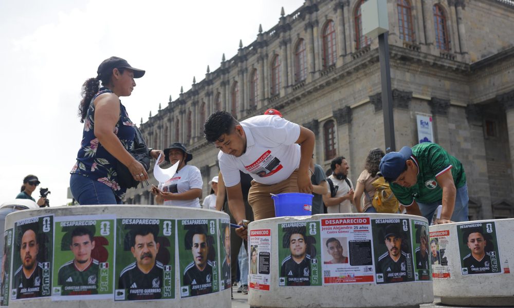 Fotografía del 31 de mayo de 2026, de personas pegando fichas de búsqueda de desaparecidos en el centro histórico de la ciudad de Guadalajara (México). EFE/ Francisco Guasco