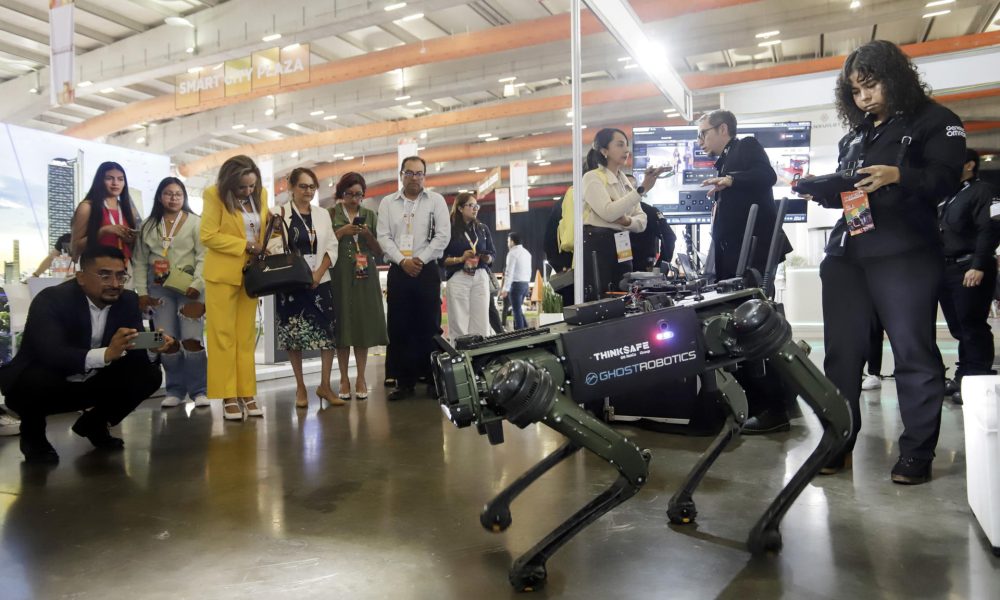 Personas observan un robot durante la inauguración del SmartCity Expo Latam Congress este martes, en la ciudad de Puebla (México). EFE/ Hilda Ríos
