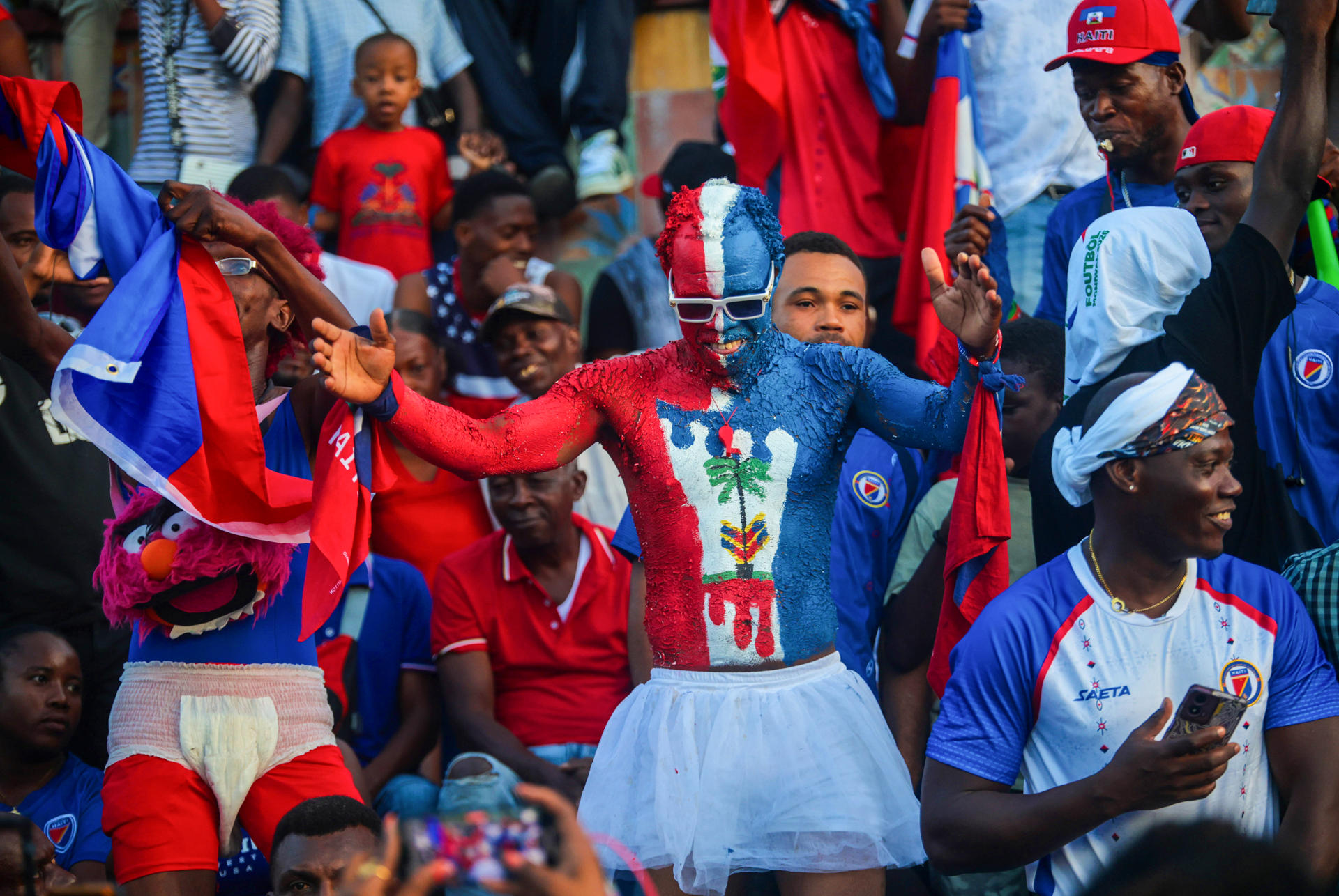Aficionados de la selección de Haití esperan el inicio del partido contra Escocia este sábado en Puerto Príncipe (Haití). EFE/ Mentor David Lorens